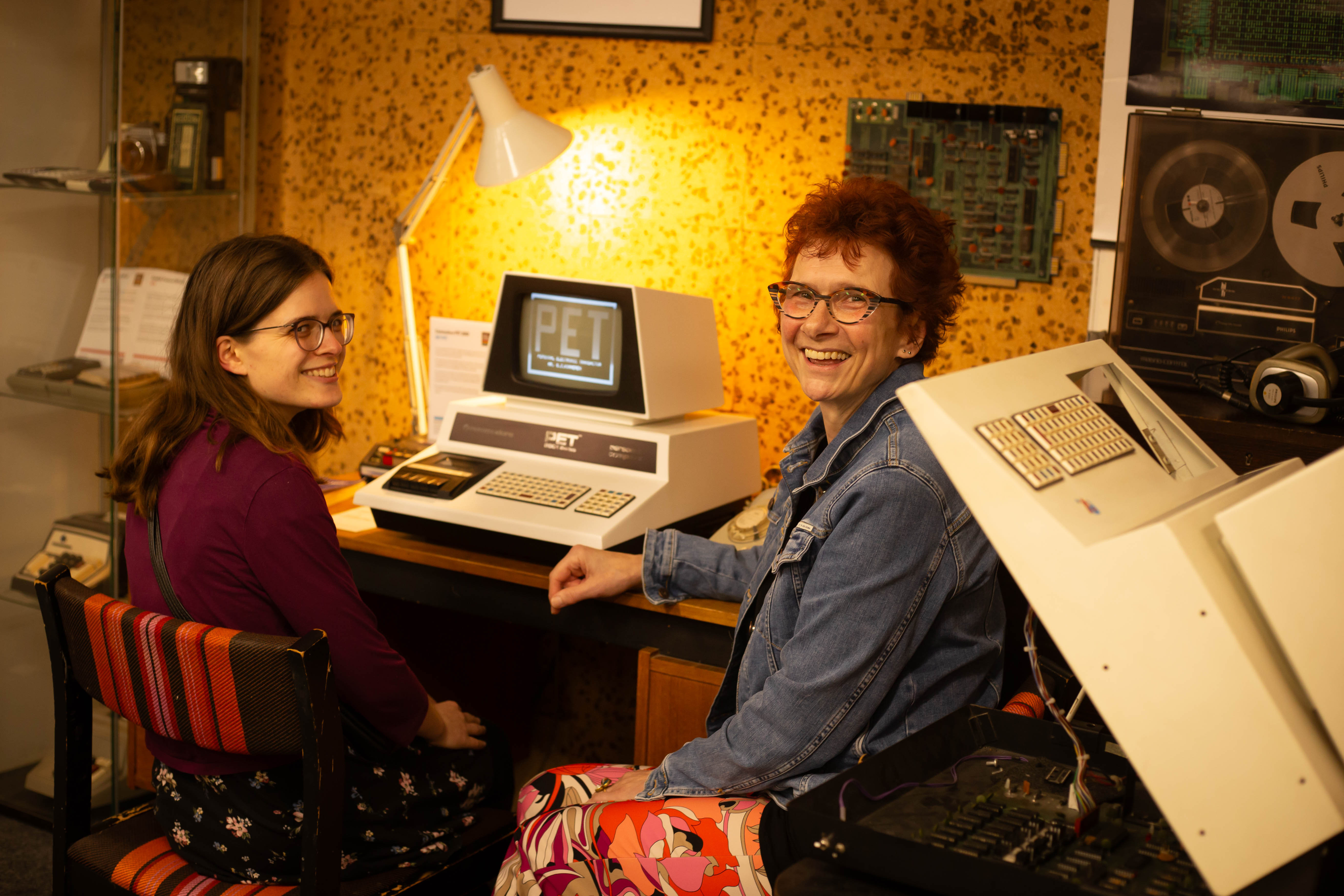 Evelien en Sabine achter een historische computer uit de jaren tachtig.